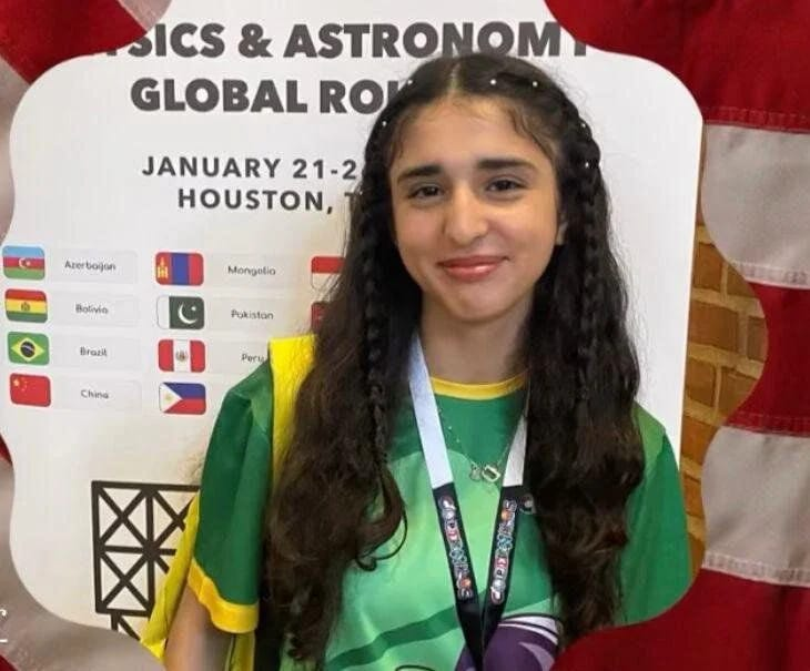 د کوټې زده کوونکې ارپنګا بریال په امریکا، هوستن کې د کوپرنیکس نیچرل ساینس اولمپیاډ پر مهال د سپینو زرو مډال سره ولاړه ده